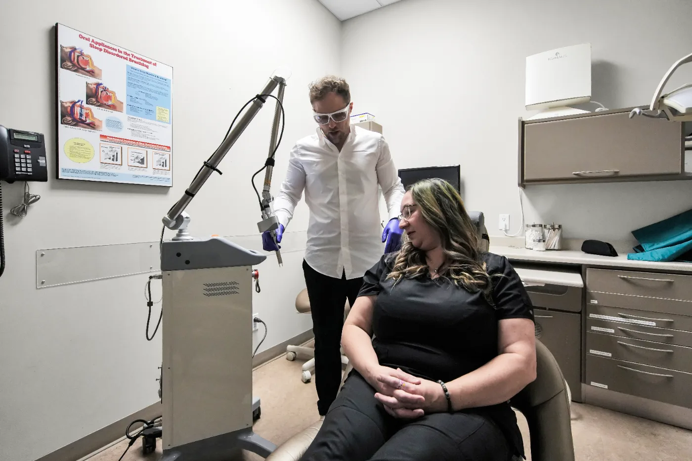 Dr. Sepehr Jafarpour performing DEKA CO₂ laser therapy on a seated patient
